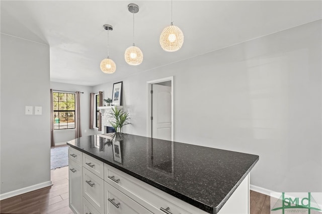 kitchen featuring pendant lighting, dark wood-style flooring, white cabinets, and a kitchen island