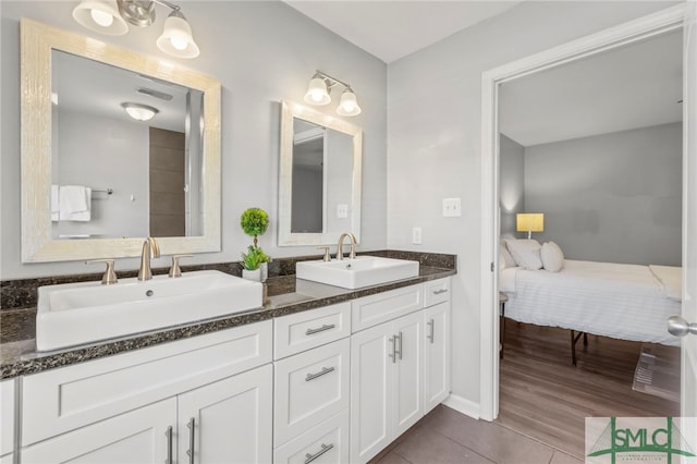 bathroom featuring double vanity, tile patterned flooring, visible vents, and a sink