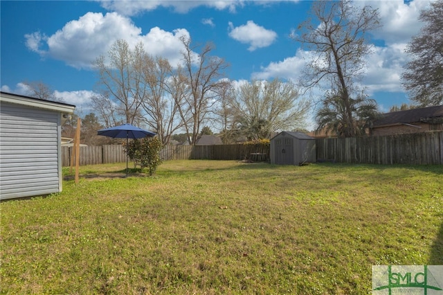 view of yard featuring a shed, a fenced backyard, and an outbuilding