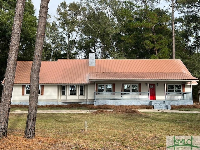 ranch-style house featuring a porch, metal roof, a chimney, and a front lawn