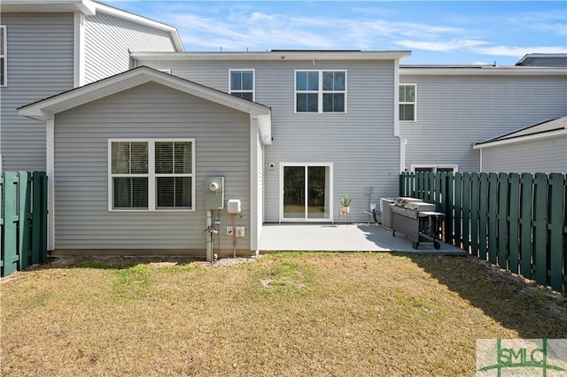 back of property featuring a fenced backyard, a patio, and a yard