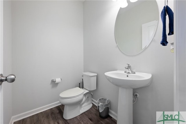 bathroom featuring toilet, baseboards, and wood finished floors