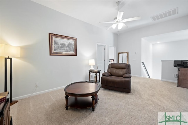 sitting room with carpet floors, baseboards, visible vents, and an upstairs landing