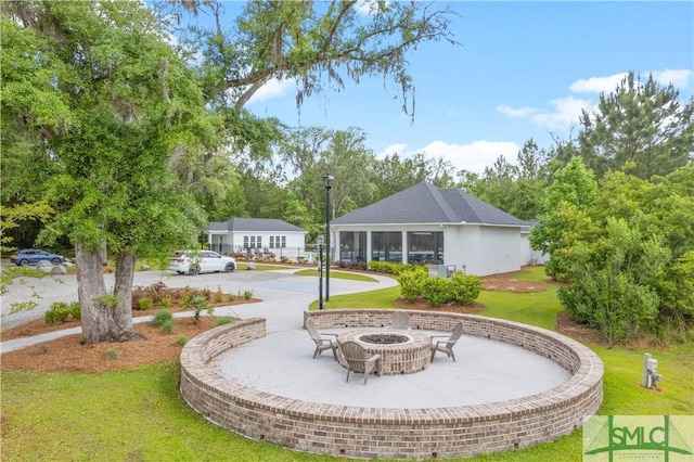 surrounding community with an outdoor fire pit, a lawn, and a patio