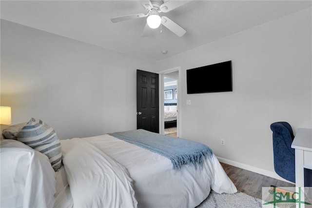 bedroom featuring ceiling fan, baseboards, and wood finished floors