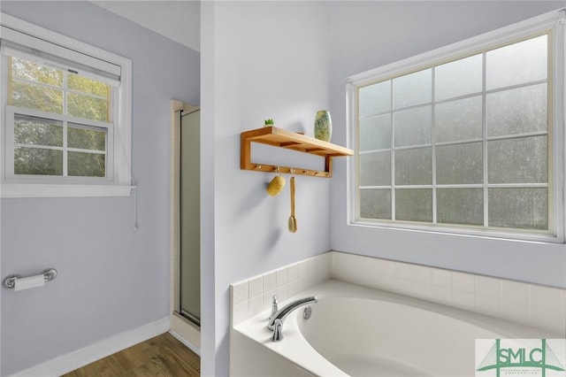 full bathroom with a stall shower, plenty of natural light, baseboards, and a garden tub