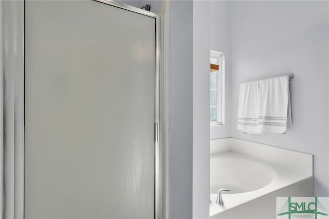 bathroom featuring a garden tub and a shower stall