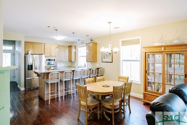 dining area featuring dark wood-style floors, visible vents, baseboards, and a notable chandelier