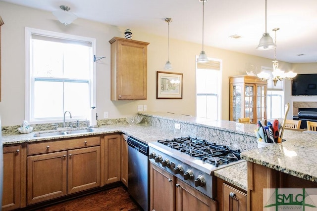 kitchen with decorative light fixtures, visible vents, appliances with stainless steel finishes, a sink, and a peninsula