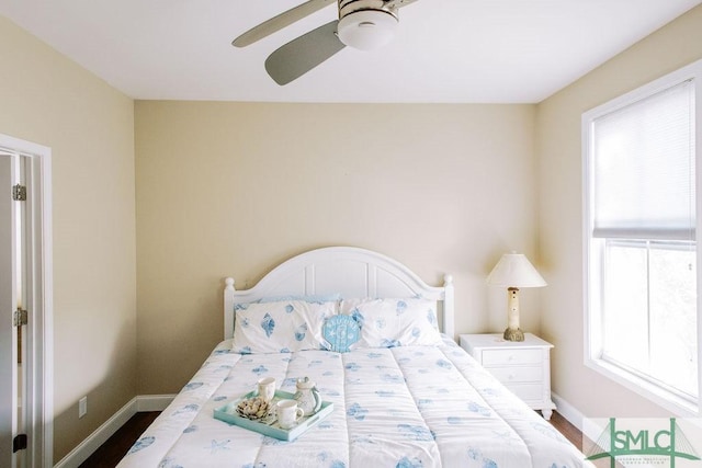 bedroom featuring multiple windows, ceiling fan, and baseboards