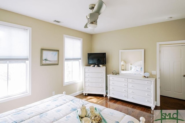 bedroom with dark wood-style flooring, visible vents, ceiling fan, and baseboards