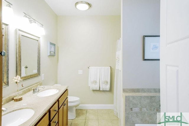 bathroom featuring double vanity, a sink, toilet, and tile patterned floors