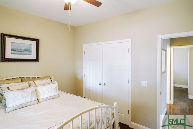 bedroom with a ceiling fan, baseboards, dark wood finished floors, and a closet