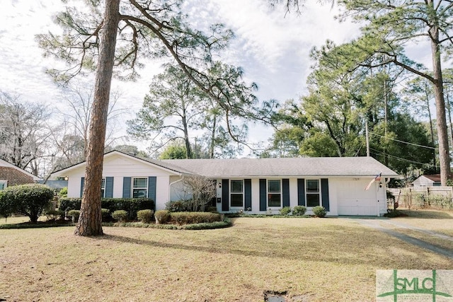 ranch-style house featuring a garage, driveway, fence, and a front lawn