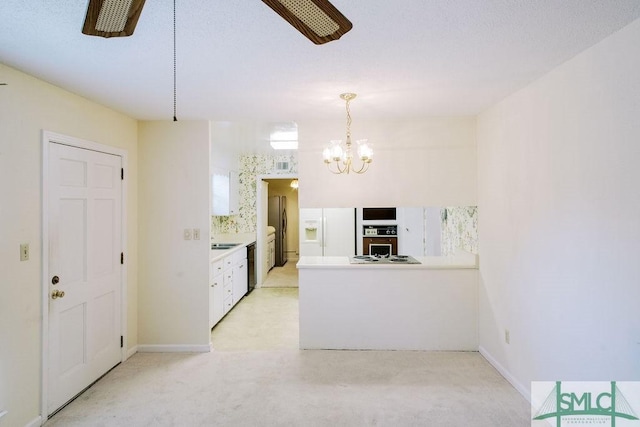 kitchen featuring ceiling fan with notable chandelier, a peninsula, white cabinets, dishwasher, and white fridge with ice dispenser