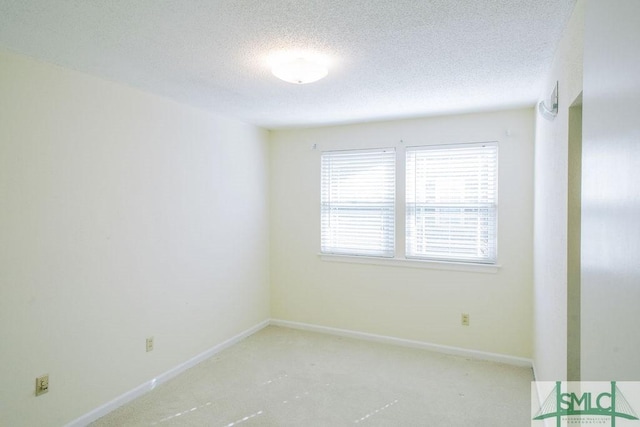 unfurnished room with a textured ceiling and baseboards