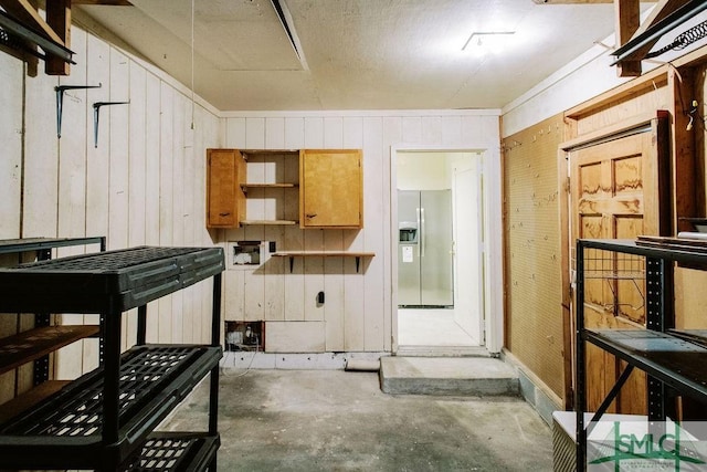 kitchen featuring open shelves, unfinished concrete flooring, and stainless steel fridge with ice dispenser