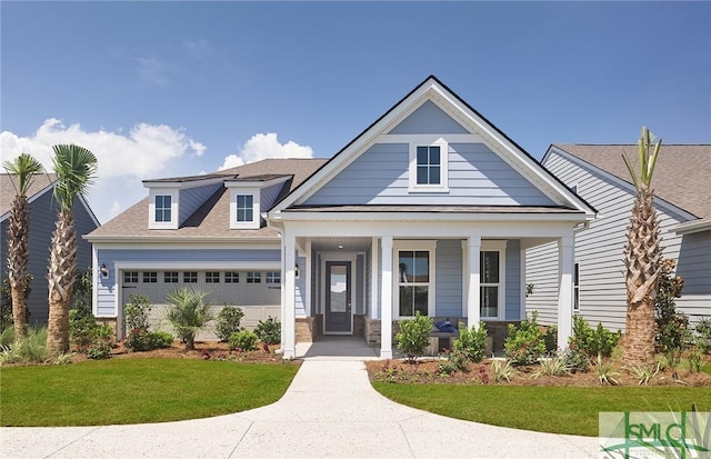 view of front of property featuring a shingled roof, covered porch, and an attached garage