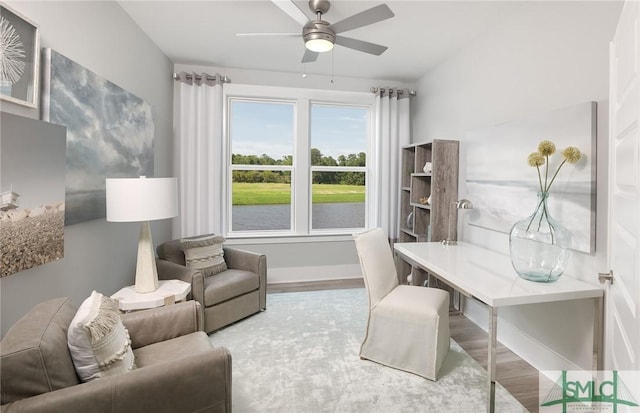office with ceiling fan, a water view, wood finished floors, and baseboards