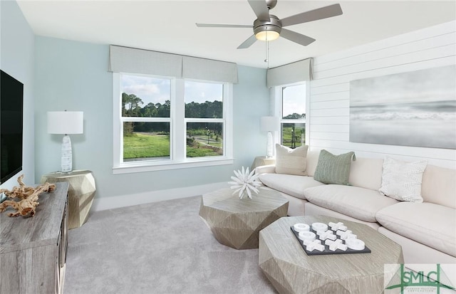 carpeted living room with baseboards and a ceiling fan