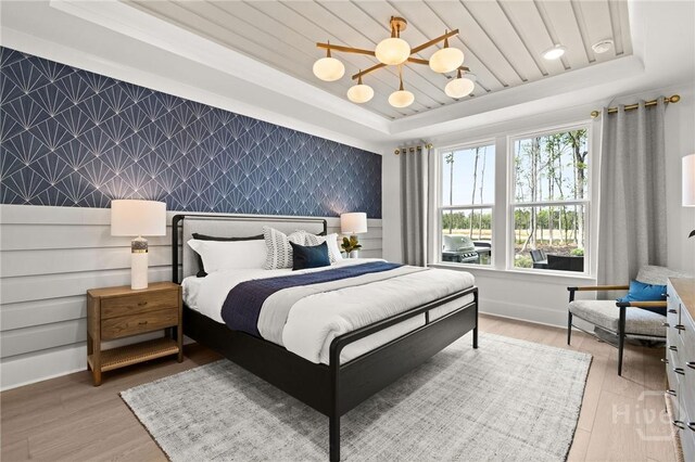 323 Birch Dr, Richmond Hill, GA 31324 - bedroom with an accent wall, wallpapered walls, a tray ceiling, light wood-style floors, and baseboards