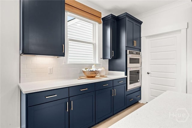323 Birch Dr, Richmond Hill, GA 31324 - kitchen featuring double oven, light countertops, backsplash, and blue cabinetry