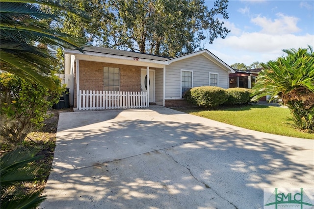 view of front of property featuring driveway, brick siding, and a front yard