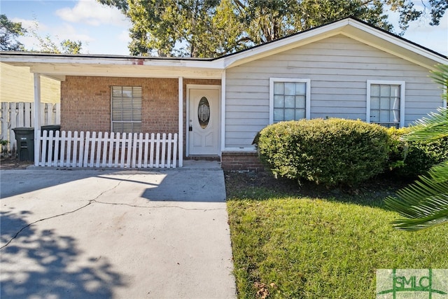 view of front of house featuring brick siding and fence