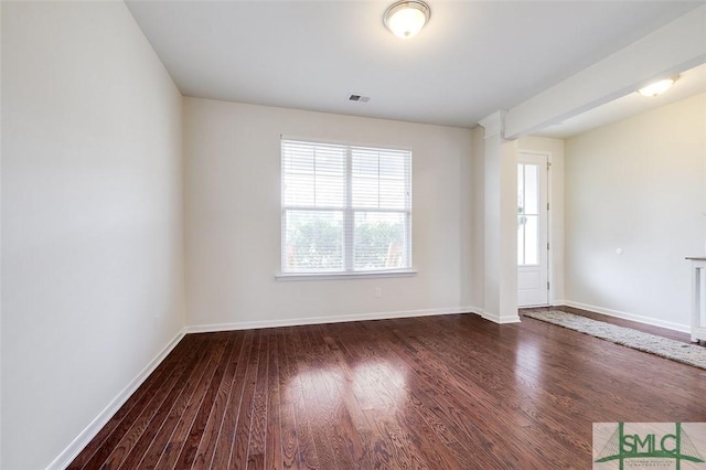 unfurnished room with visible vents, baseboards, and wood finished floors