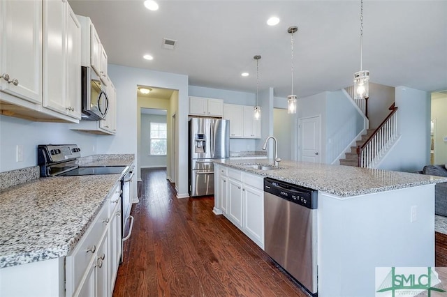 kitchen with dark wood-style floors, stainless steel appliances, visible vents, white cabinetry, and a sink