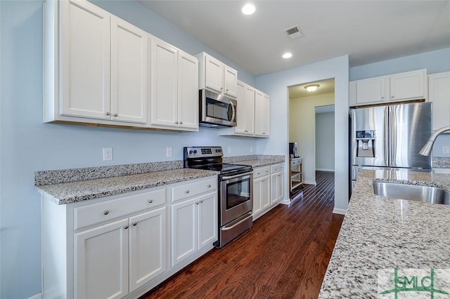 kitchen with dark wood-style flooring, a sink, visible vents, white cabinetry, and appliances with stainless steel finishes