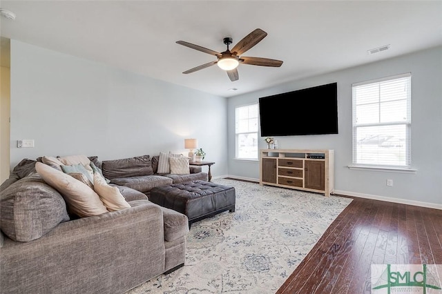 living room with a ceiling fan, wood-type flooring, visible vents, and baseboards