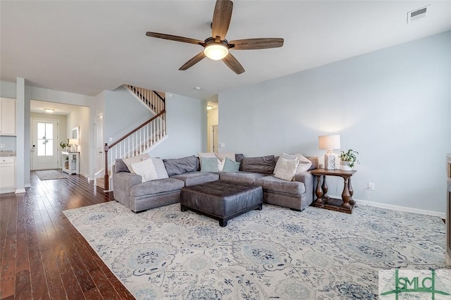 living area with wood-type flooring, visible vents, stairway, and baseboards