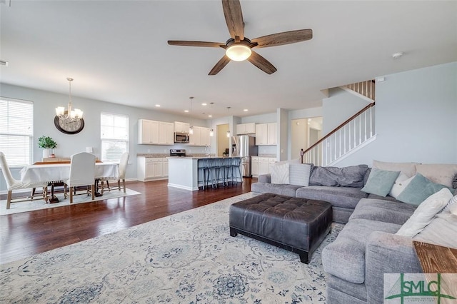 living area featuring dark wood-style floors, recessed lighting, visible vents, baseboards, and ceiling fan with notable chandelier