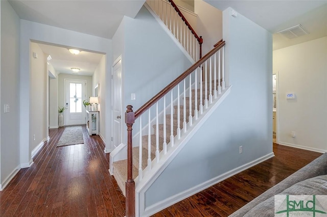 foyer entrance featuring hardwood / wood-style flooring, visible vents, and baseboards