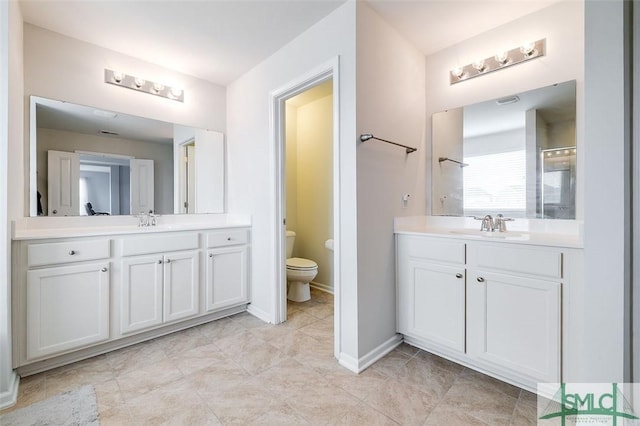 full bathroom featuring toilet, two vanities, and a sink