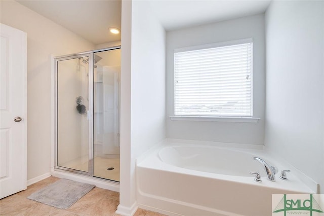 full bathroom featuring a garden tub, a shower stall, and tile patterned floors