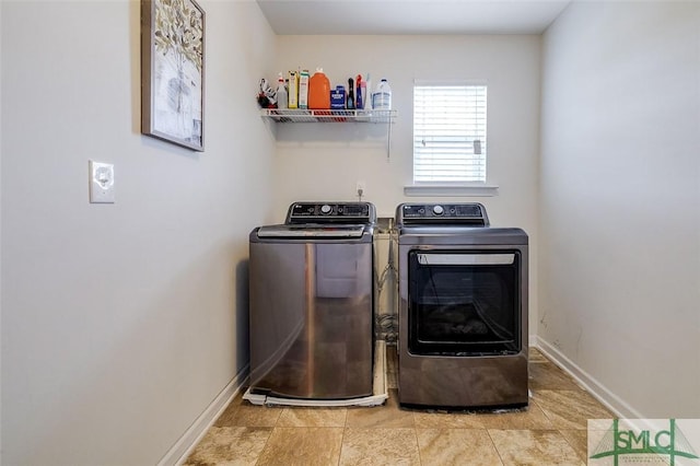 washroom featuring laundry area, baseboards, and washer and dryer