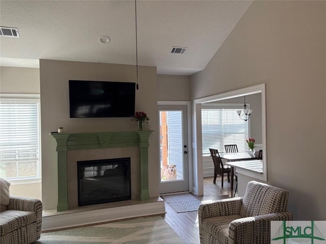 119 Sams Dr, Guyton, GA 31312 - living area featuring a fireplace, wood finished floors, a textured ceiling, and a chandelier