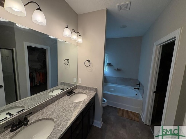 119 Sams Dr, Guyton, GA 31312 - full bath featuring a garden tub, wood finished floors, double vanity, toilet, and a spacious closet
