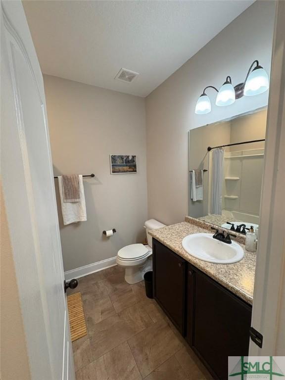 119 Sams Dr, Guyton, GA 31312 - full bathroom with vanity, toilet, a shower with curtain, and baseboards