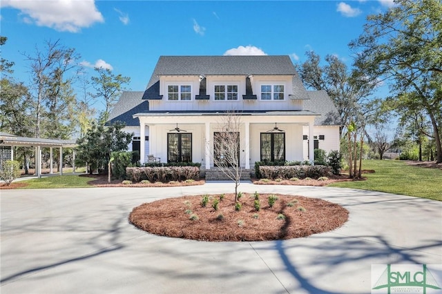 modern farmhouse featuring curved driveway, covered porch, board and batten siding, a standing seam roof, and a front lawn