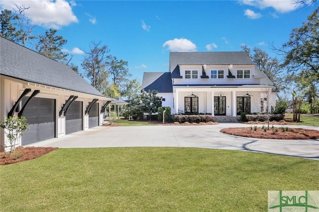 modern farmhouse style home with a front yard, concrete driveway, covered porch, and stucco siding