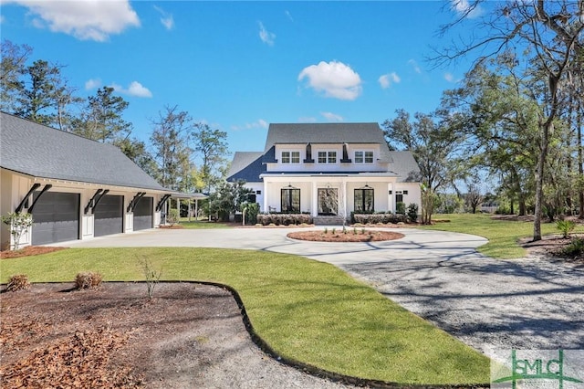 rear view of house with a garage, concrete driveway, and a yard