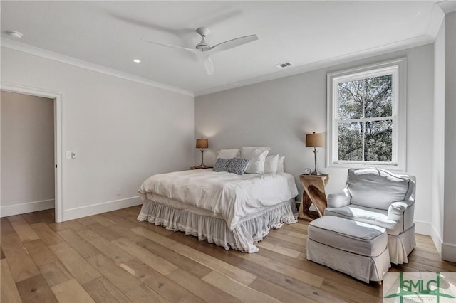 bedroom with visible vents, baseboards, hardwood / wood-style flooring, and crown molding