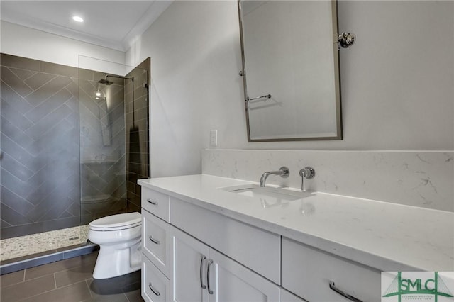 bathroom with tiled shower, tile patterned flooring, vanity, and toilet