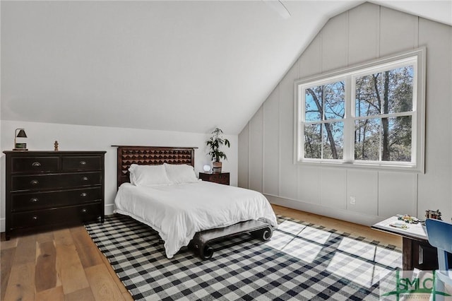 bedroom with vaulted ceiling and wood finished floors