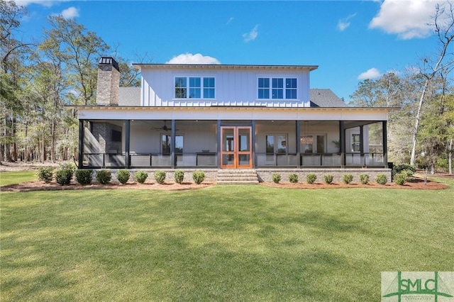 rear view of house featuring a sunroom, a yard, and a chimney