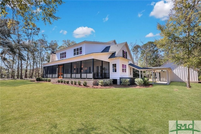 back of property featuring a yard, a chimney, and a sunroom