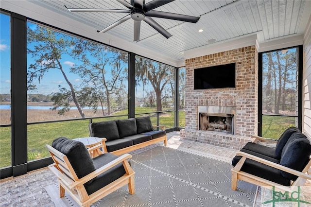 sunroom featuring a water view, wooden ceiling, ceiling fan, and a fireplace